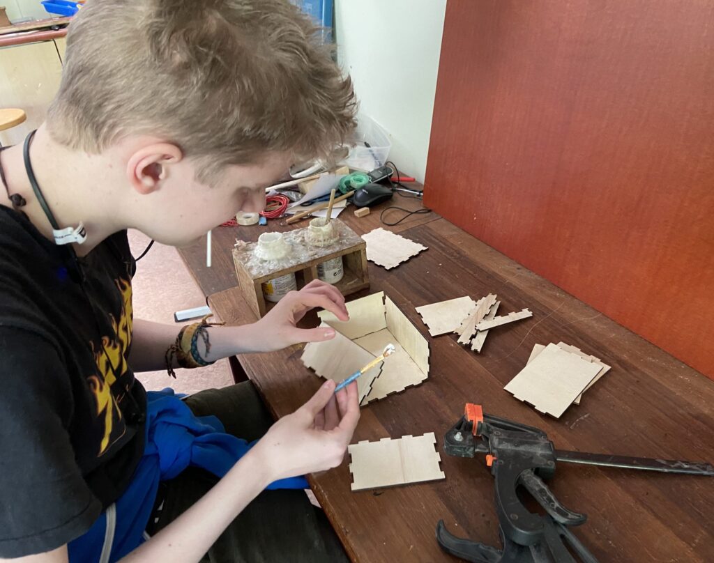 Student met bouwpakket gemaakt van hout met een lasersnijder